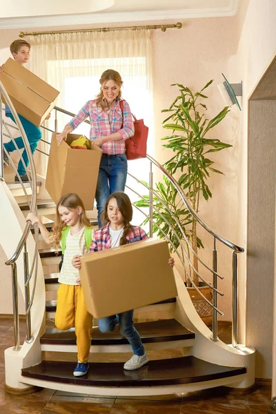 Vrouw en kinderen met vakken. — Stockfoto