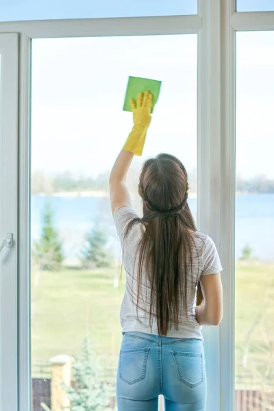Dívka s hadrem otřete okno. — Stock fotografie