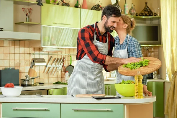 Женщина целует мужчину, кухня . — стоковое фото