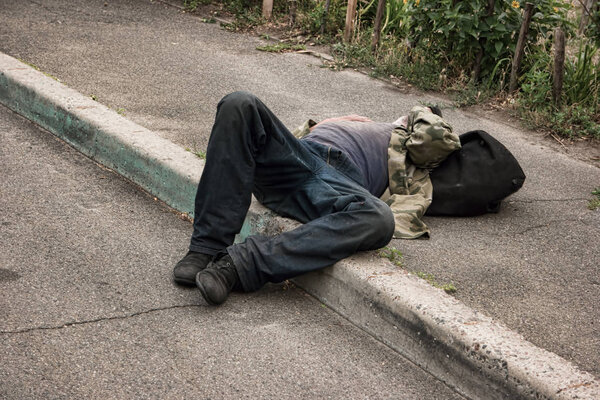Drunk person lying outdoors.