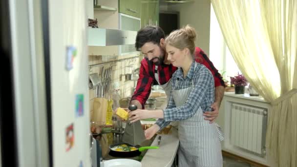 Pareja sonriendo y cocinando comida . — Vídeo de stock