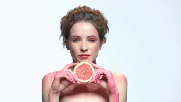 Woman holding grapefruit slice. — Stock Video