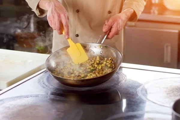 Händerna på kocken omrörning stewing grönsaker. — Stockfoto