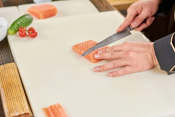 Chef affettare filetto di salmone fresco crudo . — Foto Stock