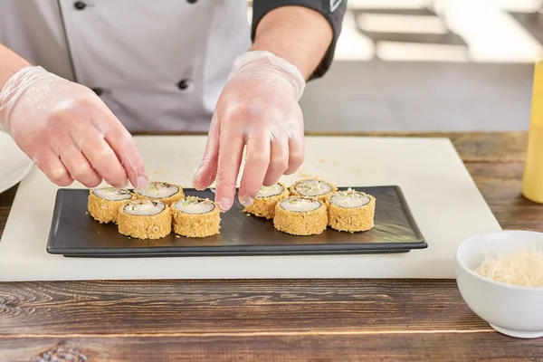 Kocken händer att sätta sushi på plattan. — Stockfoto