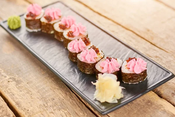 Rollos de sushi bellamente decorados en el plato . — Foto de Stock