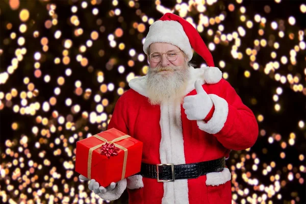 Santa med nuvarande ger tummen upp. — Stockfoto