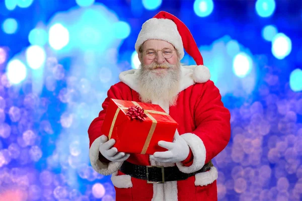 Glad jultomte holding röd presentbox. — Stockfoto