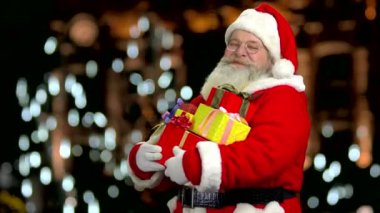 Mutlu Noel Baba holding hediyeler.