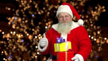 Santa gösteren başparmak yukarı, hediyeler.