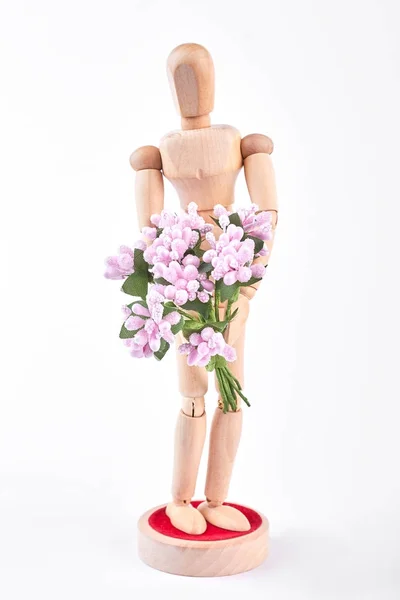 Maniquí de madera sosteniendo flores rosadas . —  Fotos de Stock