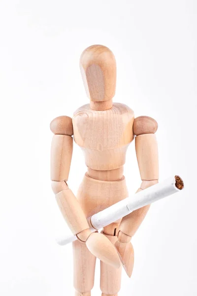 Wooden dummy with white cigarette.
