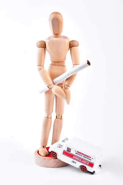 Wooden dummy with white cigarette.