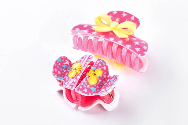 Pink plastic hair clips with bow.