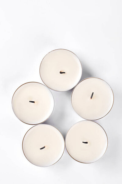 Five small round candles, top view.