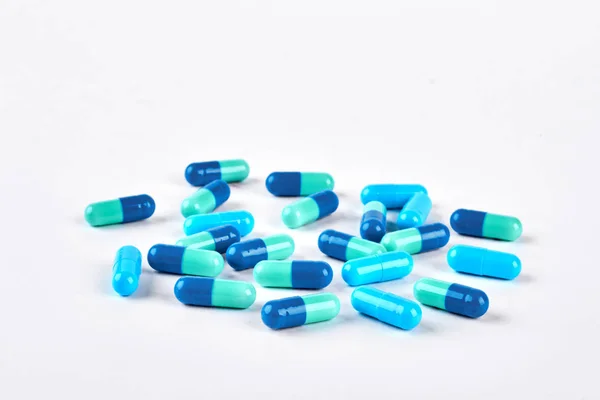 Pilha de pílulas azuis no fundo branco. — Fotografia de Stock