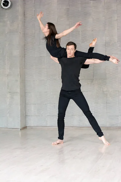 Couple in black dancing, grey background. — Stock Photo, Image