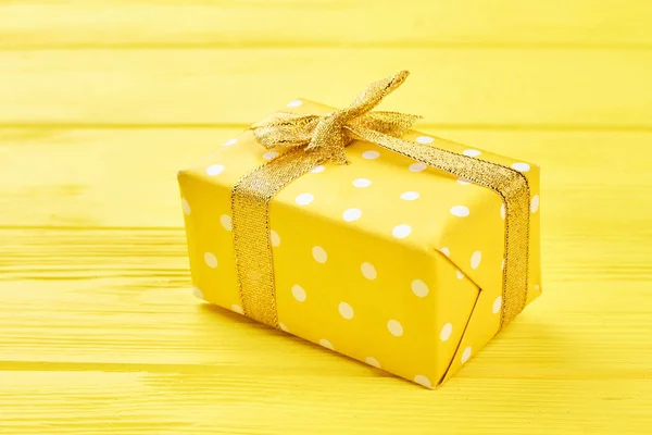 Gelbe Geschenkbox auf gelbem Hintergrund. — Stockfoto
