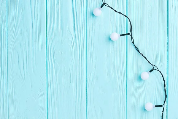 Mavi ahşap arka planda Noel ışıkları. — Stok fotoğraf