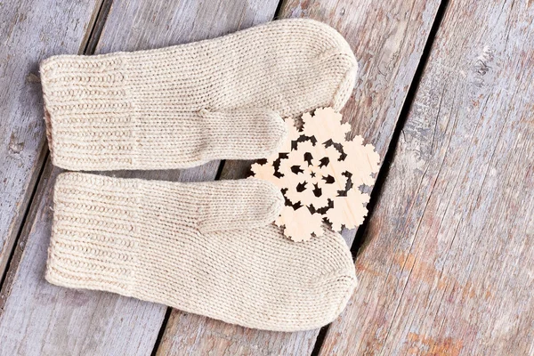 Вовняні рукавички та дерев'яна вирізана сніжинка . — стокове фото