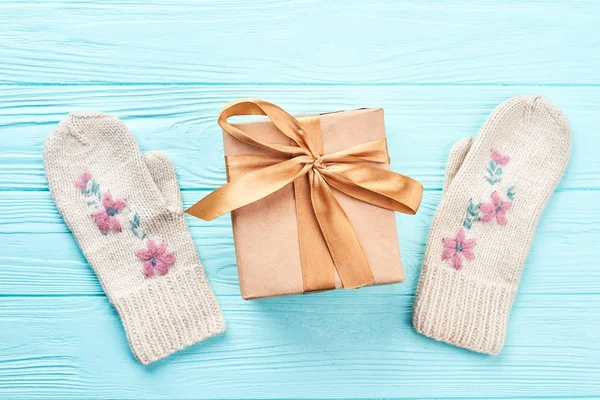 Gift box and pair of female knitted mittens. — Stock Photo, Image