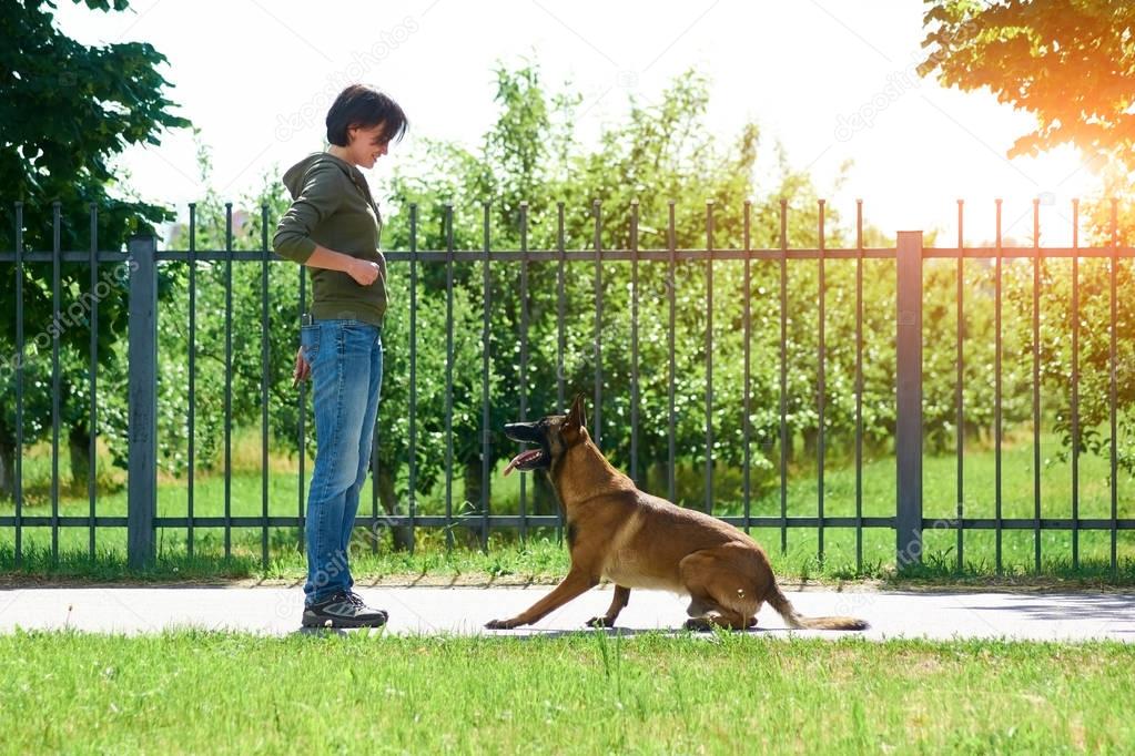 The woman is training her dog within restricted area.