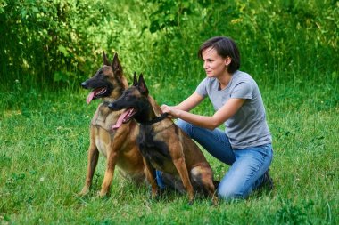 Kadın onun köpekleri tutuyor.