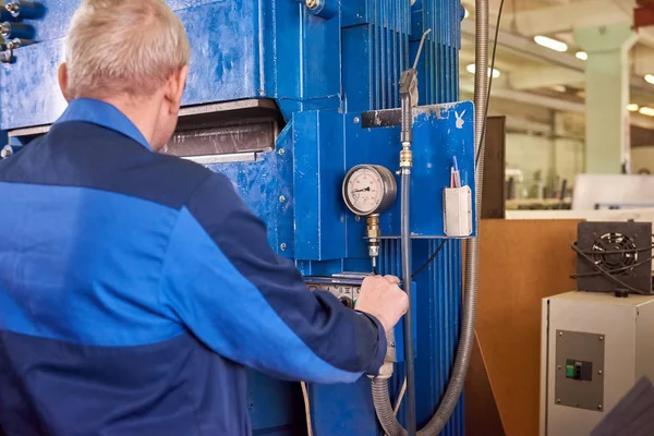 Człowiek pracy prasa hydrauliczna maszyna. — Zdjęcie stockowe