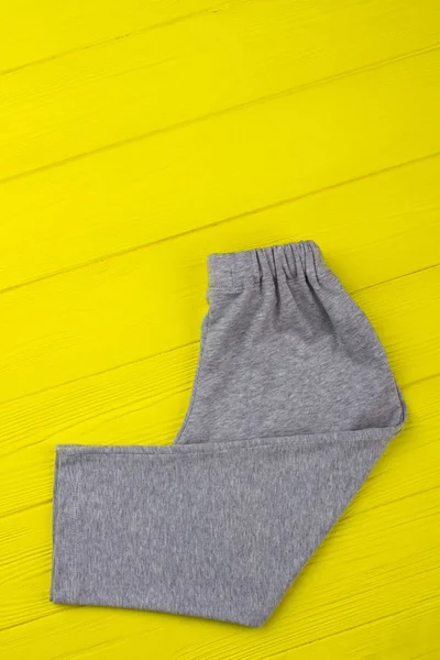 Gray sweatpants on yellow shelf — Stock Photo, Image