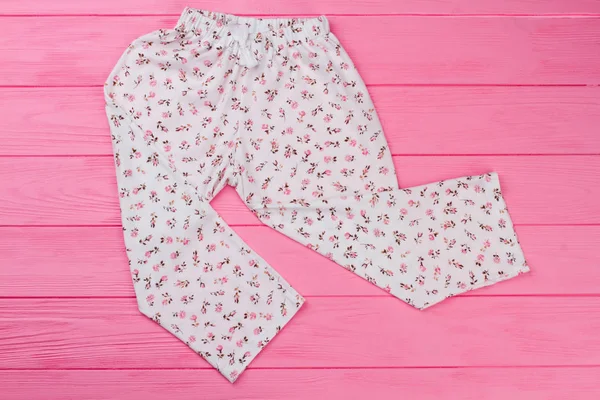 Pembe bir arka plan üzerinde gevşek pantolon