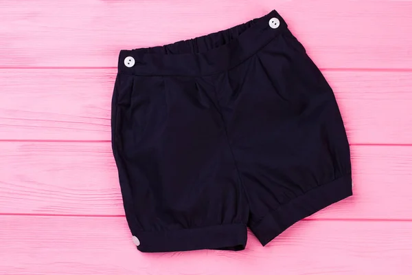 ピンクの背景にネイビーのショート パンツ — ストック写真
