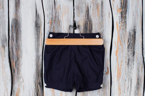 Pantalones cortos para niños en percha de madera — Foto de Stock