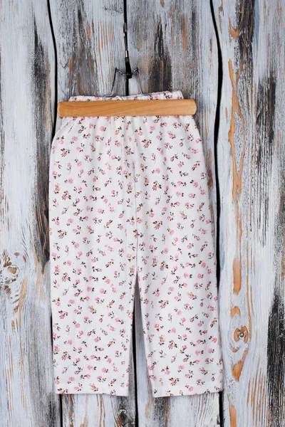 Floral pants on wooden hanger — Stock Photo, Image