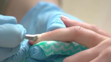 Manikürcü genç kadın için çivi Temizleme.