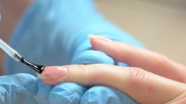 Cerrar el proceso de aplicación de esmalte en las uñas . — Vídeo de stock
