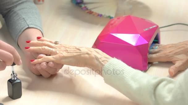 Ηλικιωμένη γυναίκα παίρνει μανικιούρ σε σαλόνι νυχιών. — Αρχείο Βίντεο