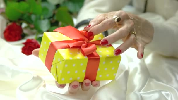 Caixa de presente amarelo em mãos femininas . — Vídeo de Stock
