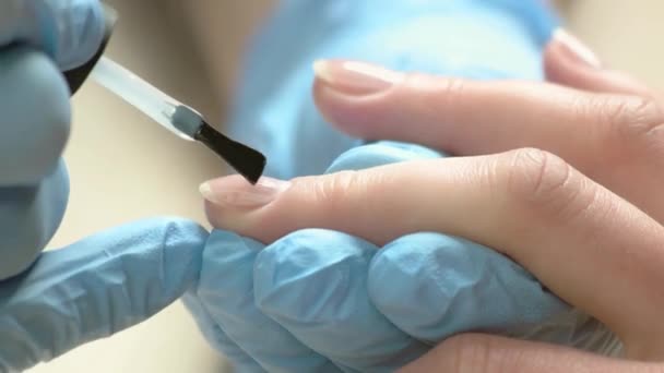 Косметолог ногтей наносит бесцветный лак . — стоковое видео