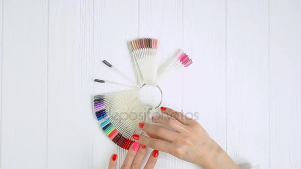 Mãos femininas experimentando amostra de unhas rosa . — Vídeo de Stock