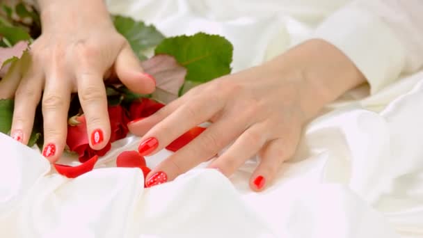 Female hands with roses on white silk. — Stock Video