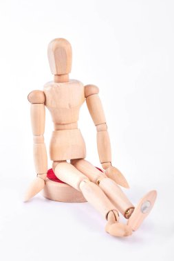 Beyaz arka plan üzerinde oturan ahşap kukla.