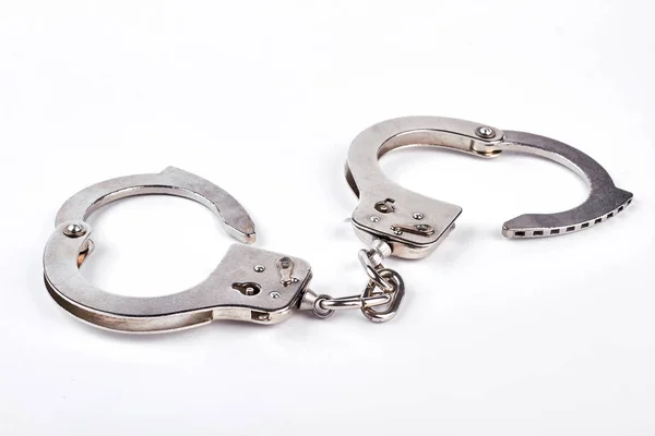 Пара металевих наручників на білому тлі . — стокове фото