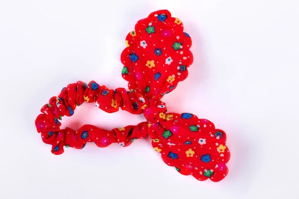 Rood textiel haar scrunchy met een patroon van bloemen. — Stockfoto