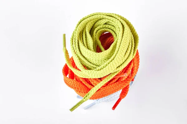 Zásobník zelené a oranžové tkaničky. — Stock fotografie