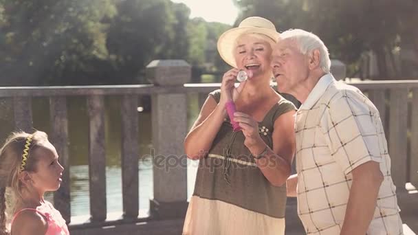Бабушка с дедушкой и внучка на улице . — стоковое видео