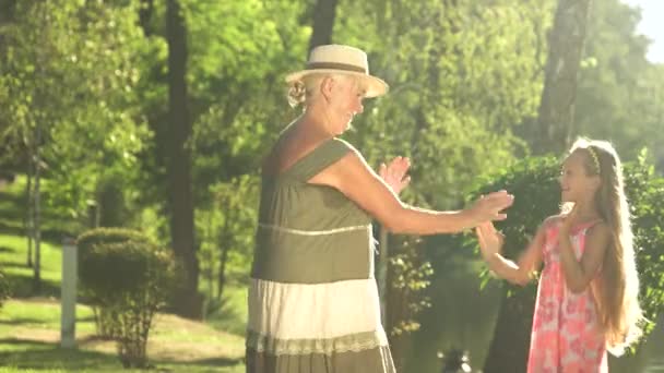 Grand-mère jouant avec sa petite-fille à l'extérieur . — Video