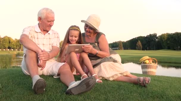 Flicka med morföräldrar holding pc tablet. — Stockvideo