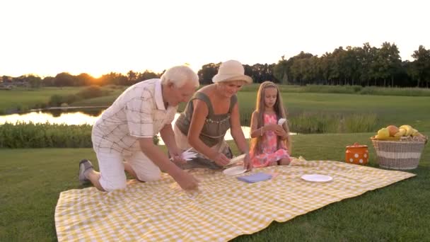 Grandparents and granddaughter outdoors. — Stock Video