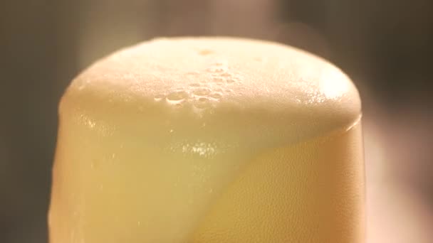 Close up foam leaking out of glass of beer. — Stock Video