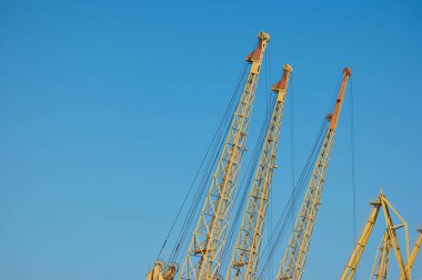 Yellow crane against blue sky. clipart